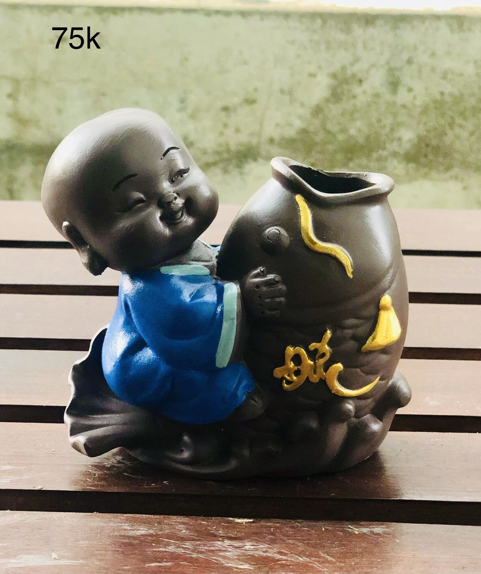Tượng chú tiểu ôm chậu cây phong thuỷ