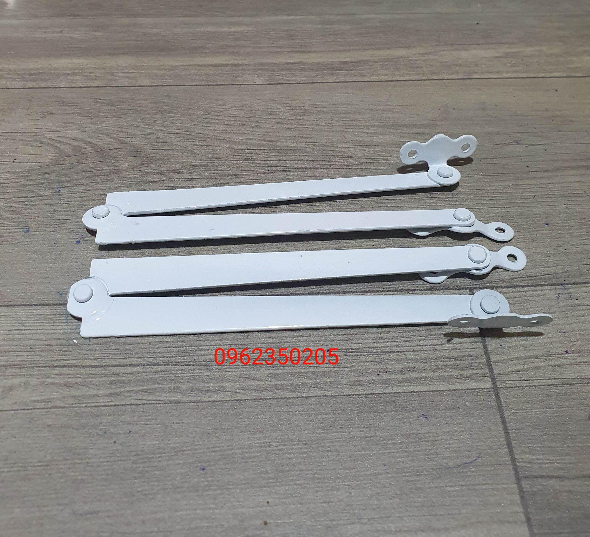 Một cặp chống sắt cửa sổ bật màu trắng sữa.