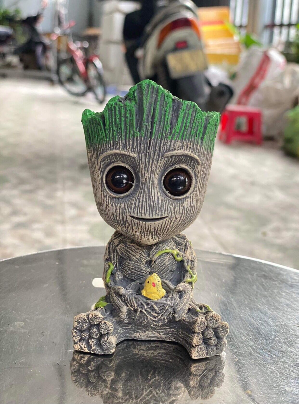 Sủi oxi đẹp hình tượng groot cầm chim và hoa