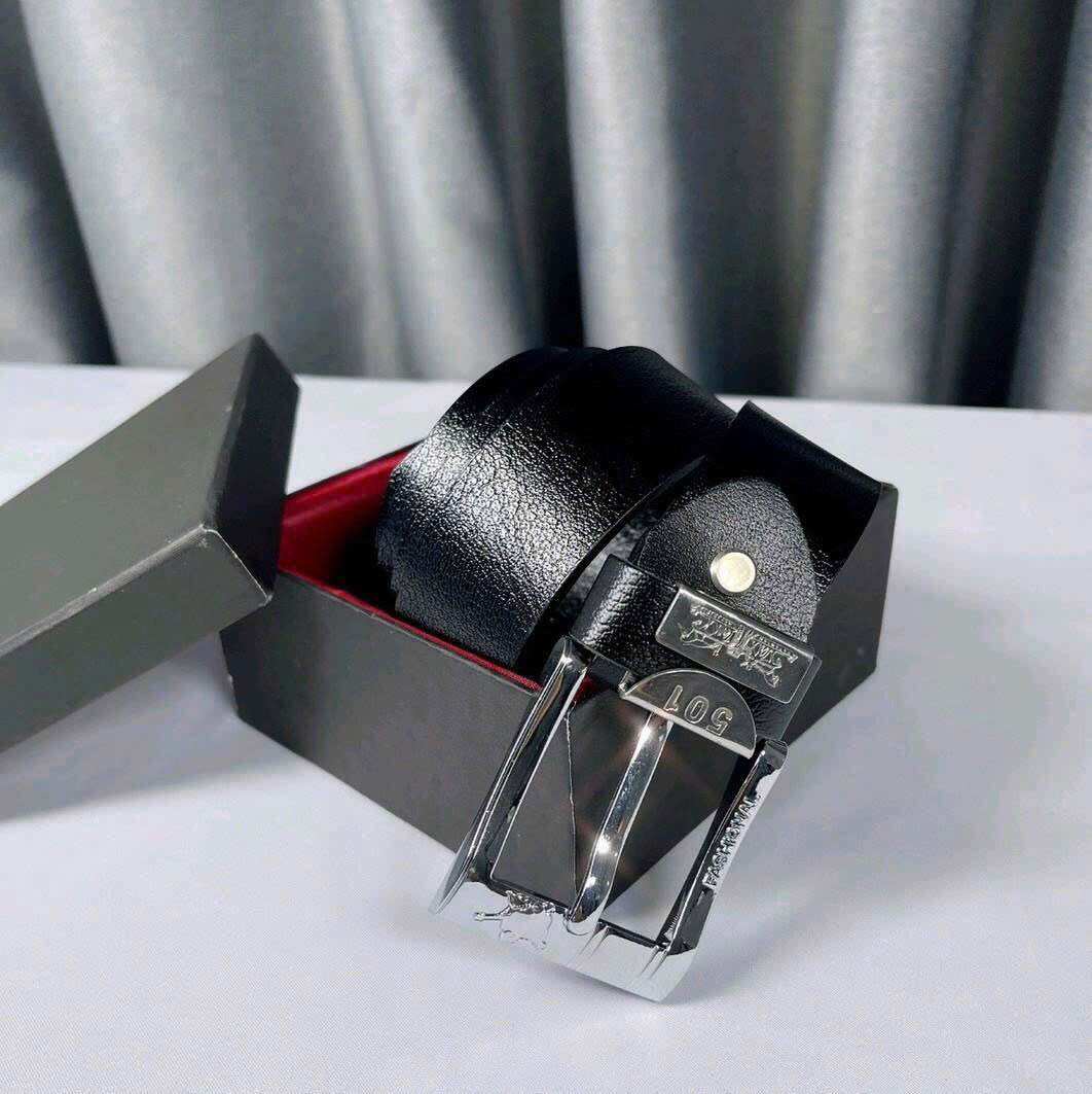 Thắt lưng da đen sang trọng với khóa kim loại sáng bóng, được đặt trong hộp quà màu đen với lớp lót đỏ, phù hợp cho trang phục công sở hoặc sự kiện trang trọng.