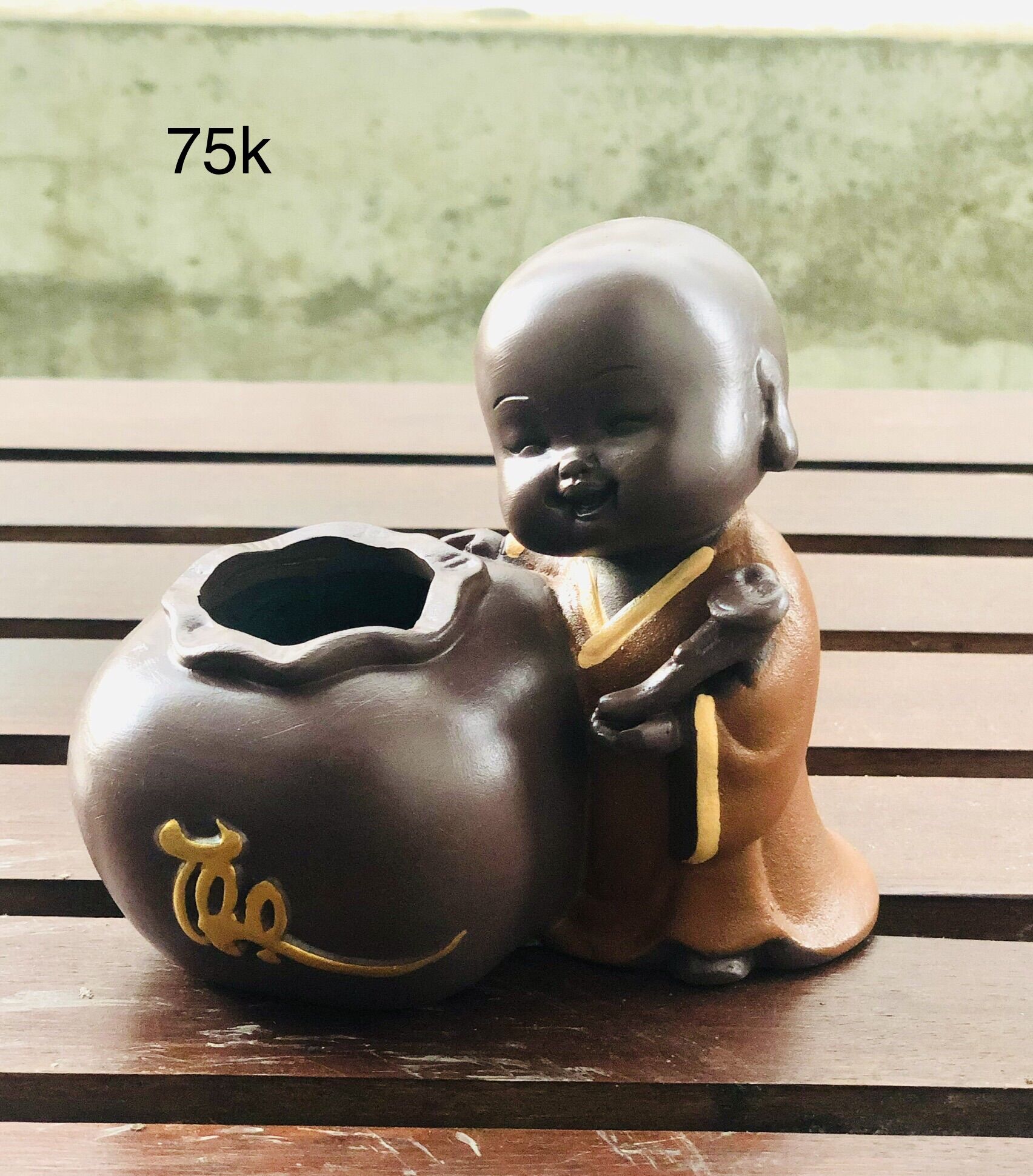 Tượng chú tiểu ôm chậu cây phong thuỷ