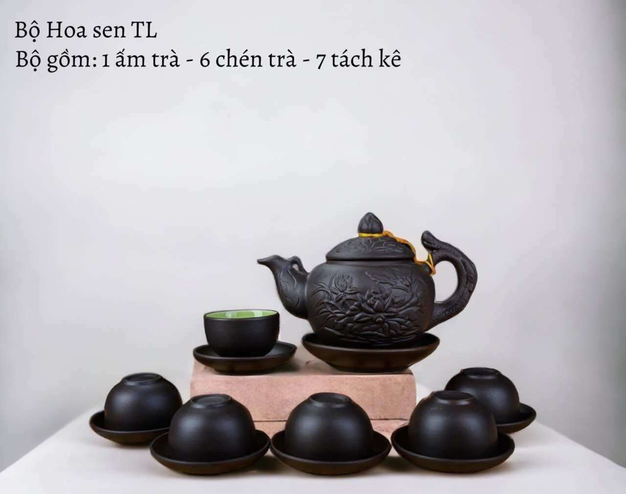 Bộ ấm chén tử sa đen đắp nổi hoa sen lòng xanh.