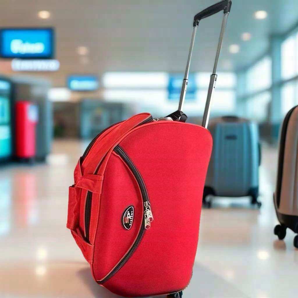 Vali kéo màu đỏ với tay cầm telescopic và logo hình khiên. Phù hợp cho du lịch và di chuyển tại sân bay.