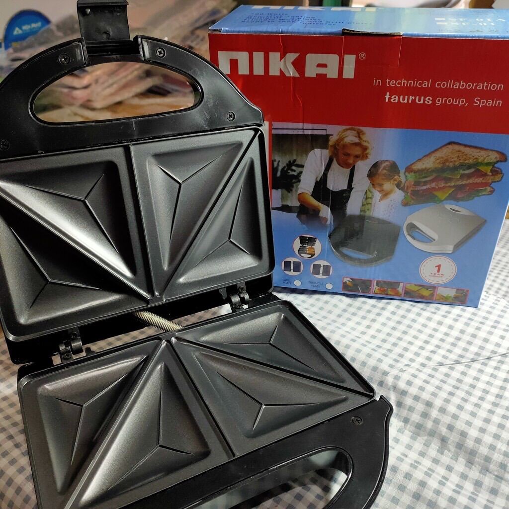 máy nướng bánh mỳ nikai .Máy màu đen điện áp 230v/50hz cong suất 700ư kích thước 22x22x7cm khối lượng 900 g .chất liệu nhựa kim loại.Khuôn bánh 4hình tam giác thời gian nướng 5-7 phút sau khi chín rơ le cảm bién tự ngắt
