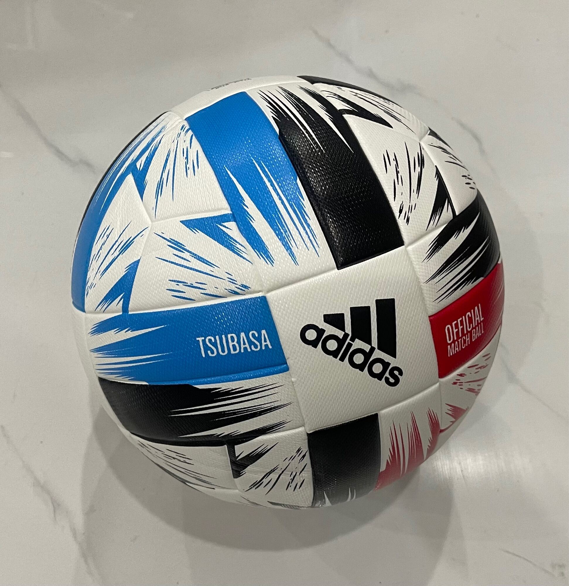 Bóng đúc cao cấp Adidas Tsubasa OMB- White Solar Red Glory Blue Blacktặng