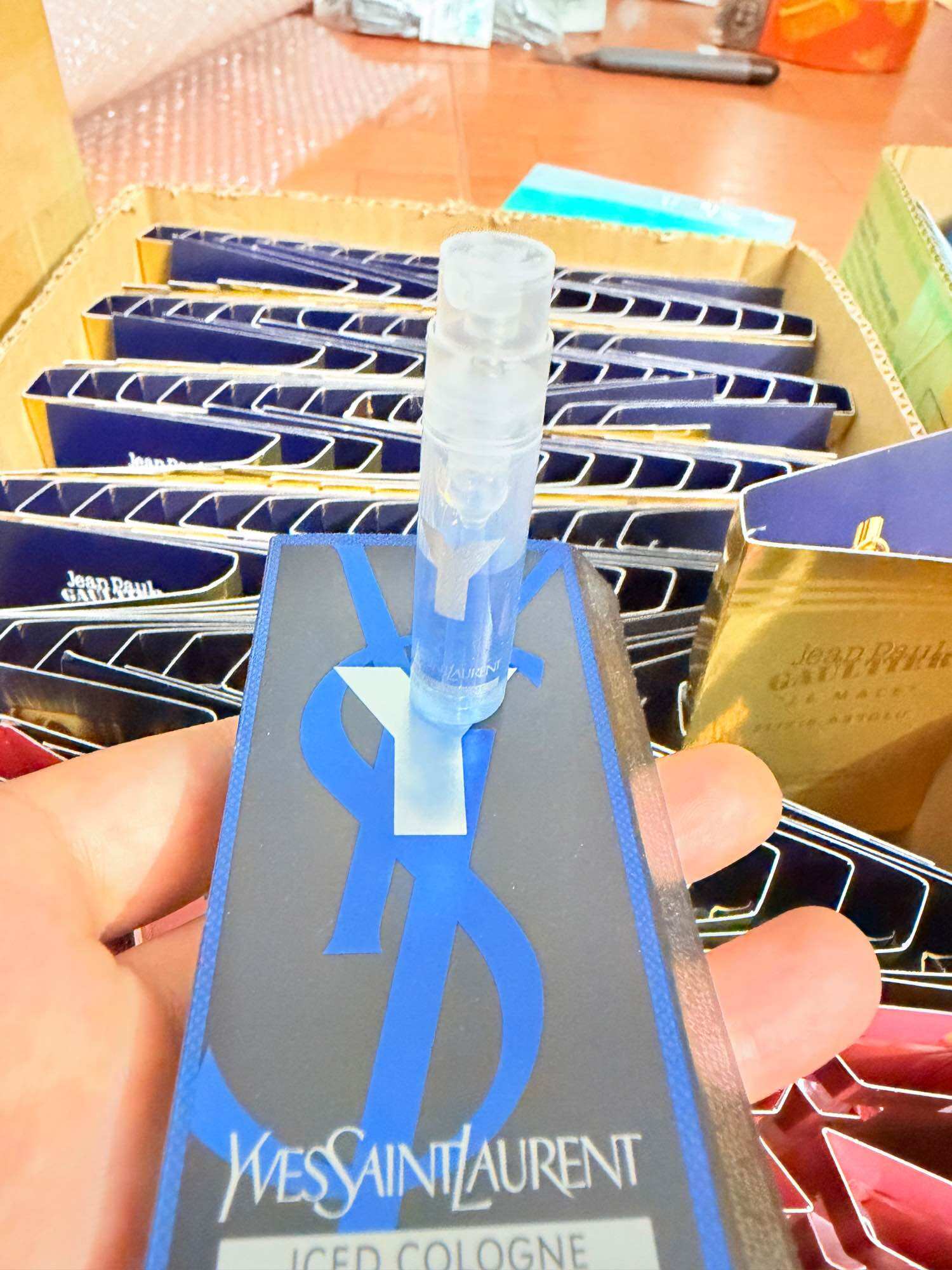 Yves Saint Laurent Iced Cologne chai nhỏ trong suốt với nắp màu trắng và hộp màu xanh dương đậm.