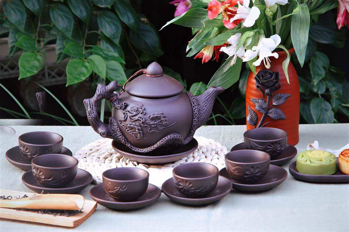 Bộ ấm chén tử sa đen đắp nổi hoa sen lòng xanh.