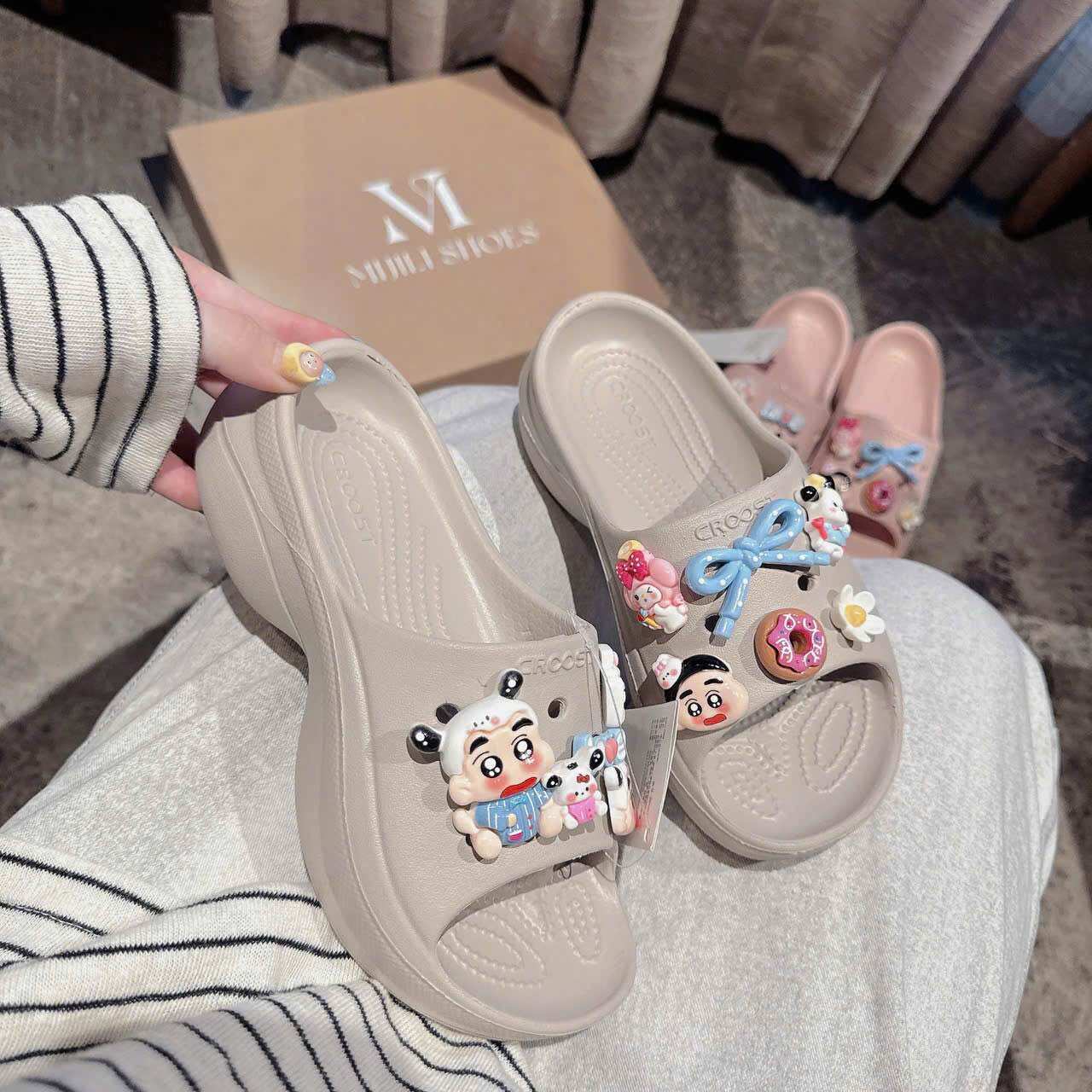 Giày sandal trẻ em màu be với họa tiết hoạt hình và phụ kiện trang trí.