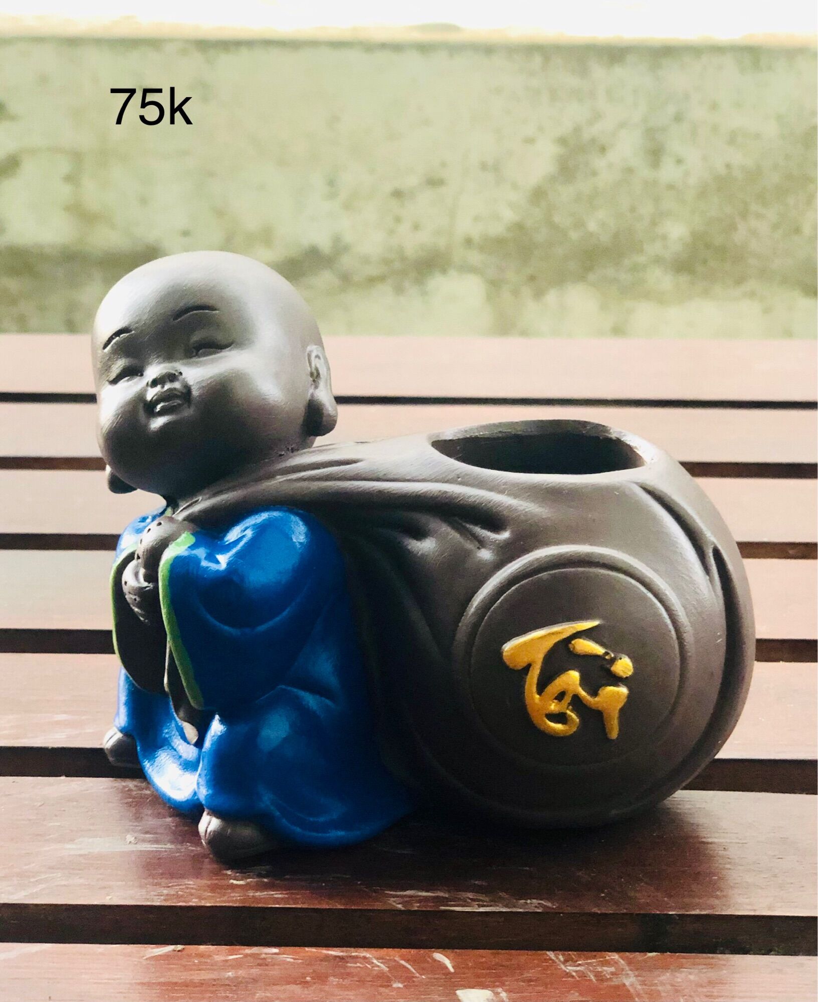 Tượng chú tiểu ôm chậu cây phong thuỷ