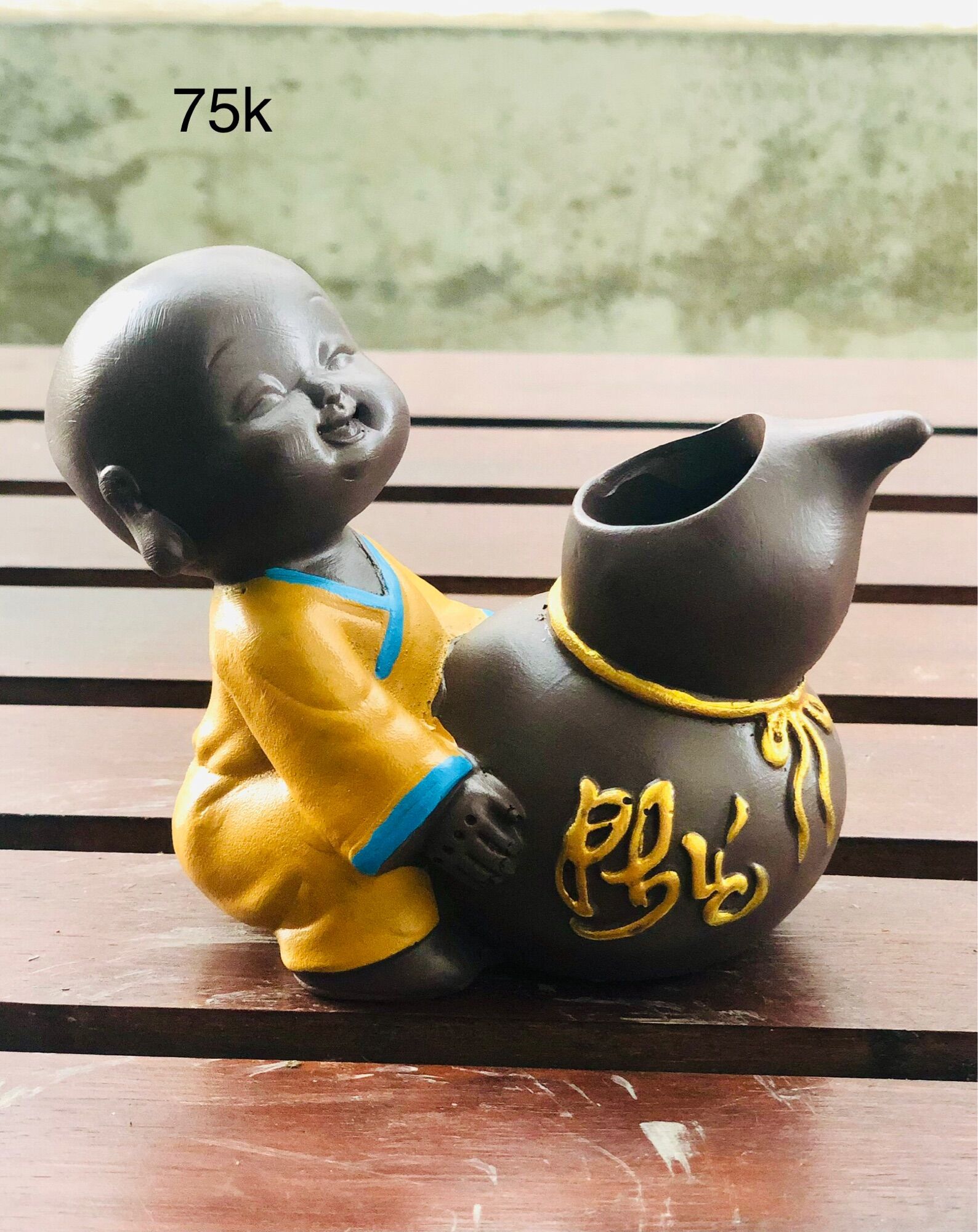 Tượng chú tiểu ôm chậu cây phong thuỷ
