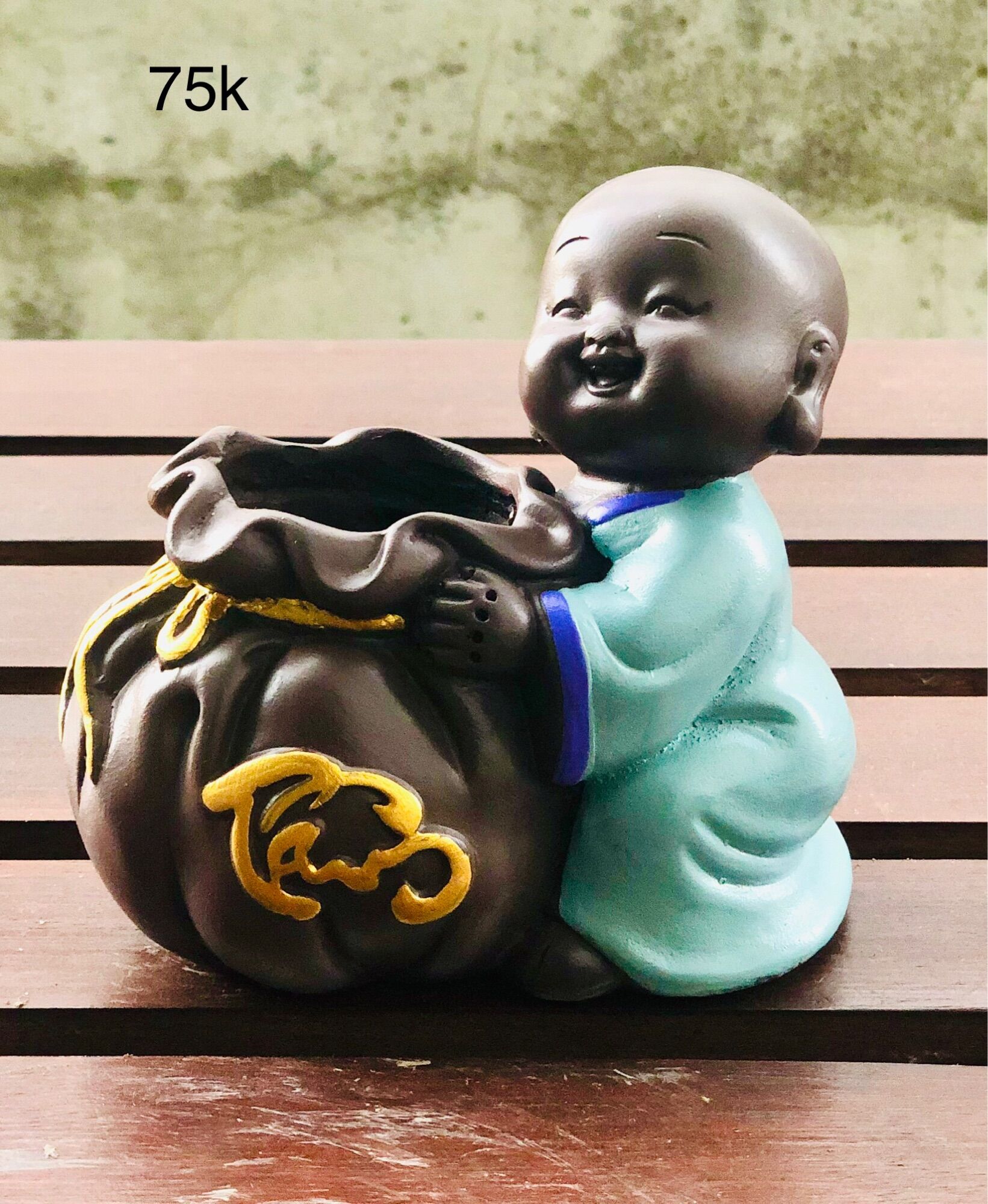 Tượng chú tiểu ôm chậu cây phong thuỷ